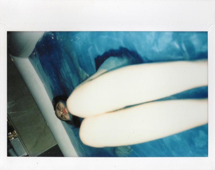 Fragmented Polaroid of a person reclining in a bathtub