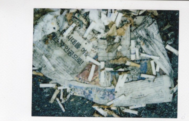Discarded cigarettes and paper on the ground