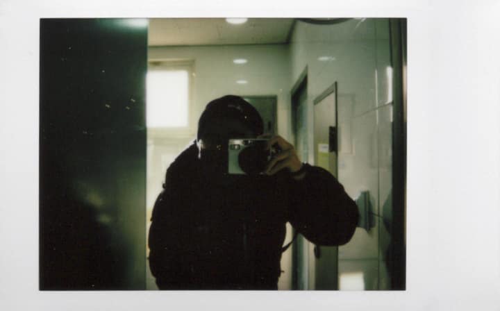 Mirror self-portrait taken with a Polaroid camera