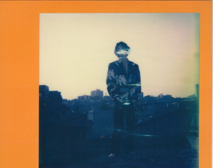 Silhouetted figure standing on a rooftop at dusk