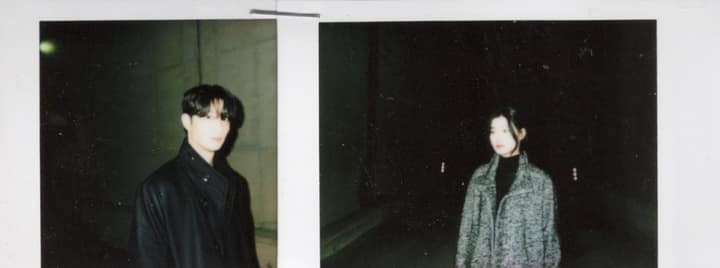 Two flash-lit figures standing apart at night