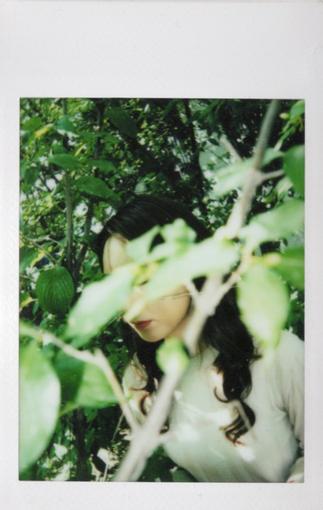 Polaroid portrait partly covered by a hand