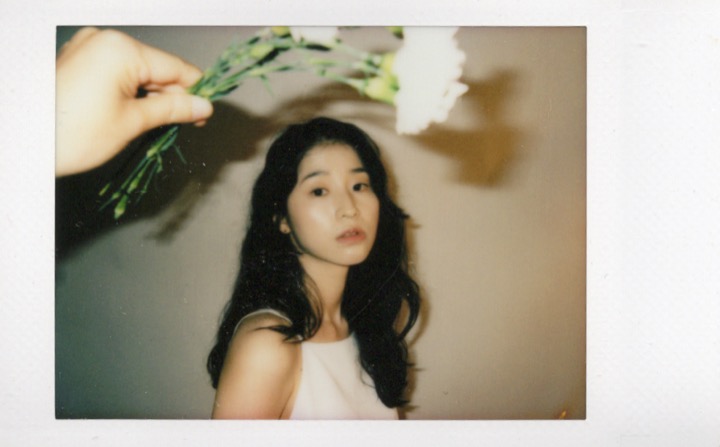 Polaroid portrait partially blocked by darkness and fabric