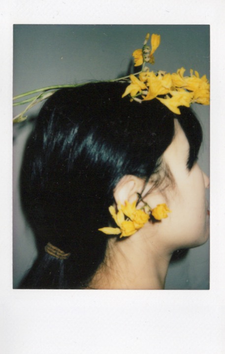 Polaroid portrait with flowers partially covering the face