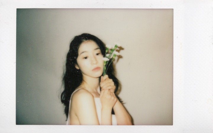 Polaroid portrait where flowers interrupt the frame
