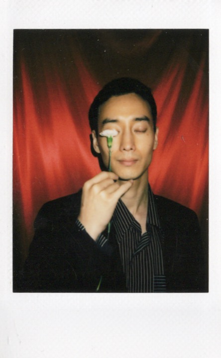 Polaroid portrait with a staged pose and soft floral detail