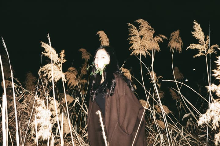Portrait among tall reeds lit by flash at night