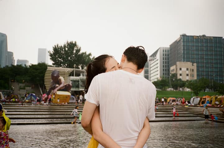 Two people seen from behind near a city river by Jeon Yoonyoung
